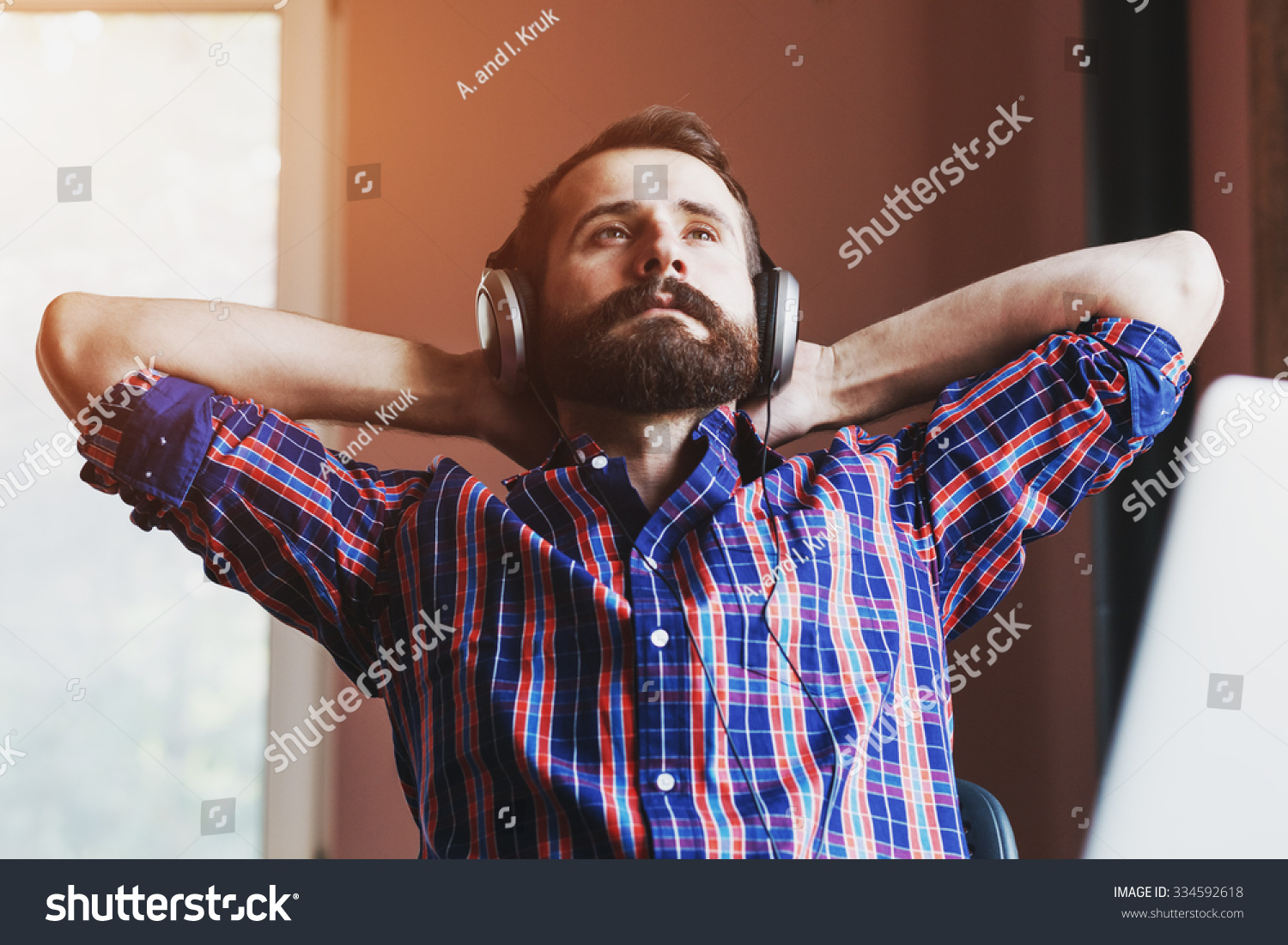 stock-photo-handsome-bearded-man-in-headphones-listening-to-music-334592618
